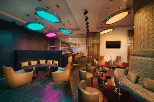a lobby with chairs and tables and a bar at Hilton Dead Sea Resort & Spa in Sowayma