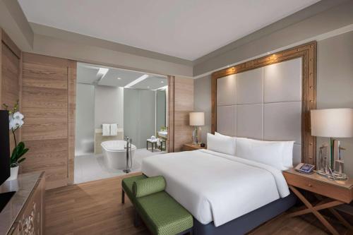 a bedroom with a large bed and a bathroom at Hilton Dead Sea Resort & Spa in Sowayma