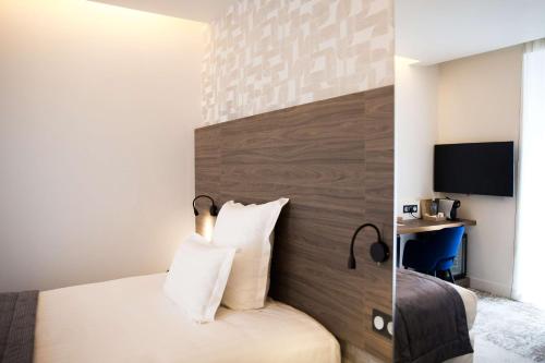 a hotel room with a bed and a desk at Le Grand Hôtel Grenoble, BW Premier Collection by Best Western in Grenoble