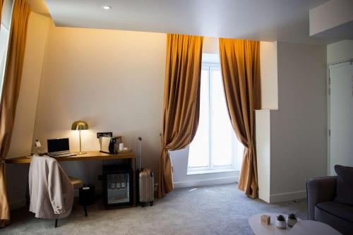 a room with a desk and a window at Le Grand Hôtel Grenoble, BW Premier Collection by Best Western in Grenoble