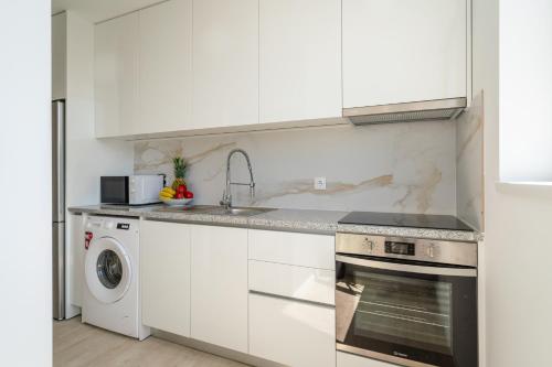 a white kitchen with a sink and a dishwasher at Host Wise - Peaceful Sunny Flat - Ace Location in Porto