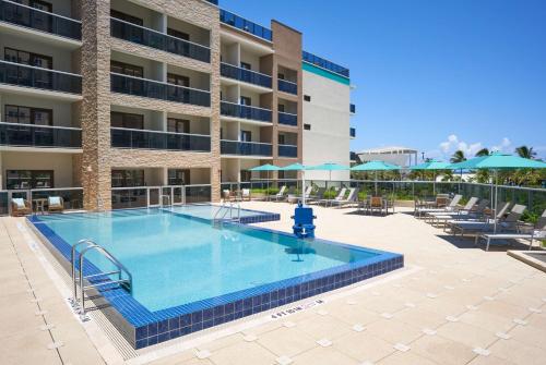 a large swimming pool in front of a building at Tru By Hilton Pompano Beach Pier in Pompano Beach