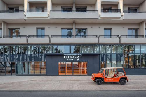 an orange jeep parked in front of a building at Canopy by Hilton Cannes in Cannes