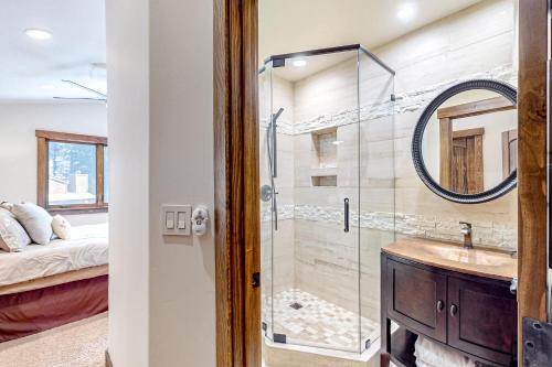 ein Bad mit einer Dusche, einem Waschbecken und einem Spiegel in der Unterkunft Moose Mountain Memories in Incline Village