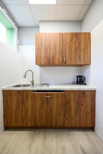 a kitchen with wooden cabinets and a sink at Pokoje Gościnne MODR in Karniowice