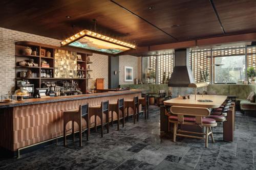 un restaurante con un bar con mesa y sillas en Tommie Austin, JDV by Hyatt en Austin
