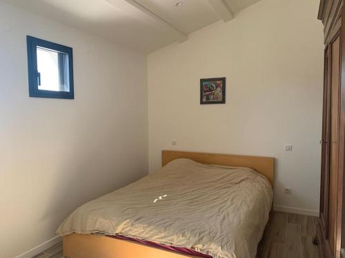 ein kleines Bett in einem Zimmer mit Fenster in der Unterkunft Maison terrasse proche centre ville et ile de Ré in La Rochelle