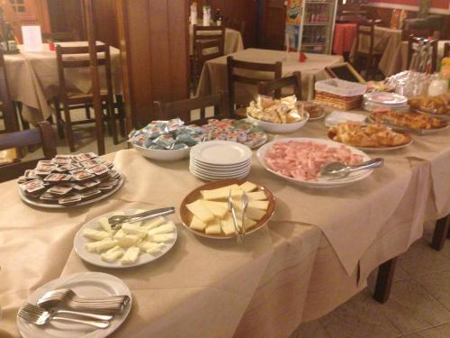 a table with many plates of food on it at Hotel Scandola in Bosco Chiesanuova
