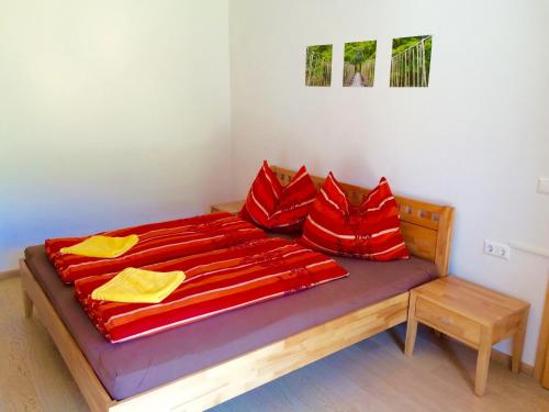 a bed with red sheets and red pillows on it at Sunny Villa in Bad Kleinkirchheim