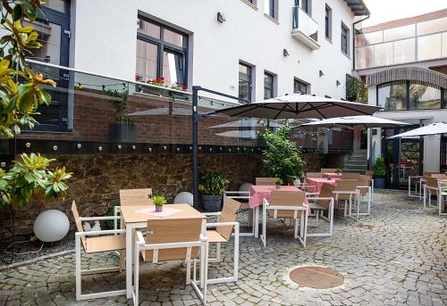 a patio with tables and chairs and umbrellas at ART Hotel in Sibiu
