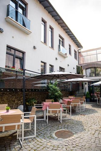 a patio with tables and chairs in front of a building at ART Hotel in Sibiu