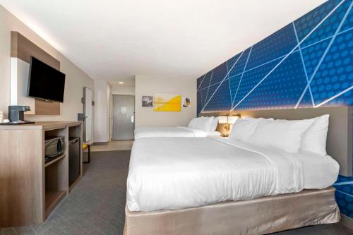 a hotel room with a large bed and a flat screen tv at Comfort Inn Edinburgh - Columbus in Edinburgh