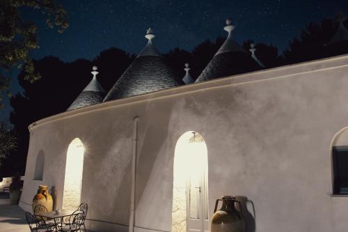 a night view of a white building with turrets at Relais I Secolari in Selva di Fasano