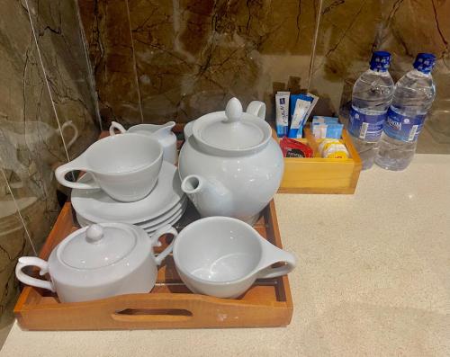 a tray with tea pots and bowls on a table at Ocean breeze Hotel Studio Negombo by Shane in Negombo