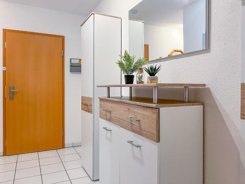 a bathroom with white cabinets and a mirror at Achtern Diek Wohnung 06 in Boltenhagen
