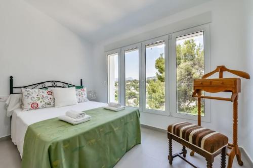 Habitación blanca con cama y ventana en Villas Guzman-Arc, en Cap Blanc
