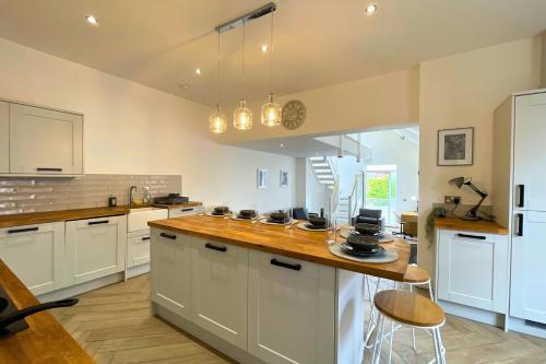 a kitchen with white cabinets and a wooden counter top at Spacious 4 Bedroom Duplex with Free Private Parking - Central Location, Near Doncaster Racecourse - Sleeps 7 in Doncaster