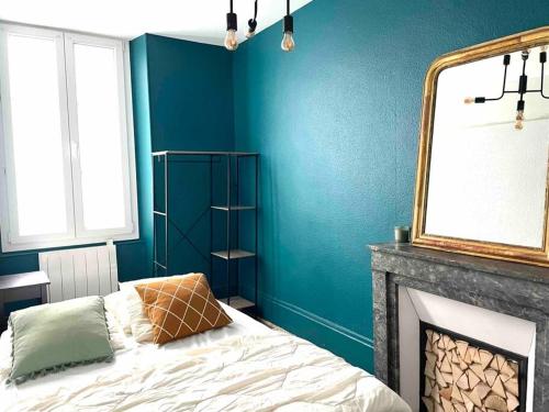 貝桑松的住宿－Grand Duplex，一间卧室设有蓝色的墙壁和一张带壁炉的床。