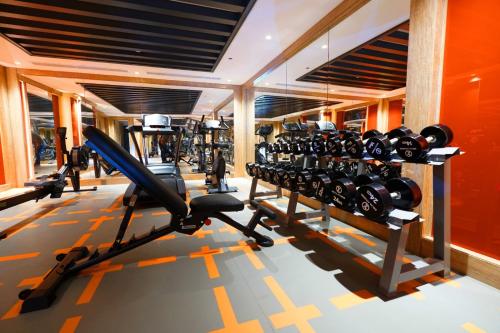 a gym with a lot of treadmills and machines at Ramada Encore Al Khobar Corniche in Al Khobar