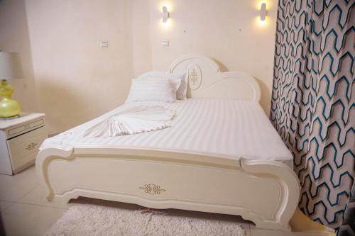 a white bed with white sheets and pillows in a bedroom at RIVER APPARTS in Brazzaville