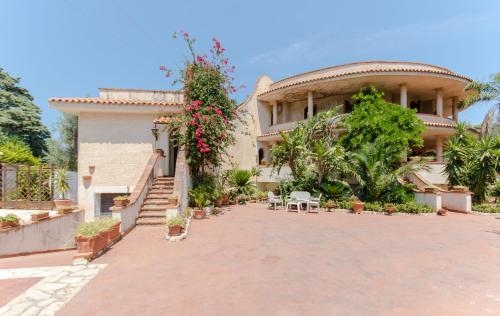 a large house with a courtyard with flowers and plants at Don Ciccio Sea House in Carini