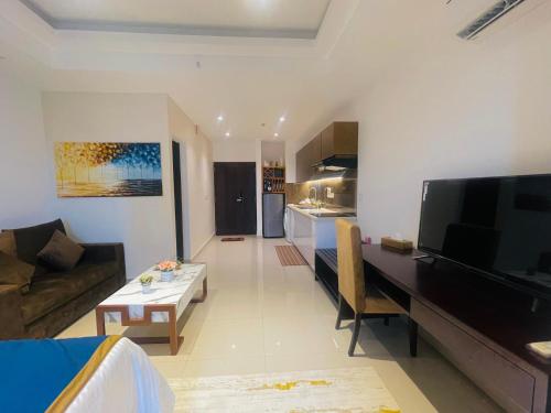a living room with a couch and a table and a television at Ocean breeze Hotel Studio Negombo by Shane in Negombo