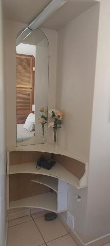 ein Badezimmer mit einem Waschtisch und einem Spiegel in der Unterkunft 1 bed garden flat in Umzumbe