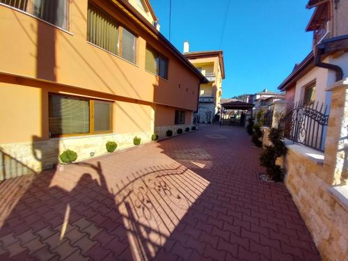 a brick walkway in front of a building at ЕЛЕГАНС къща за гости in Dospat