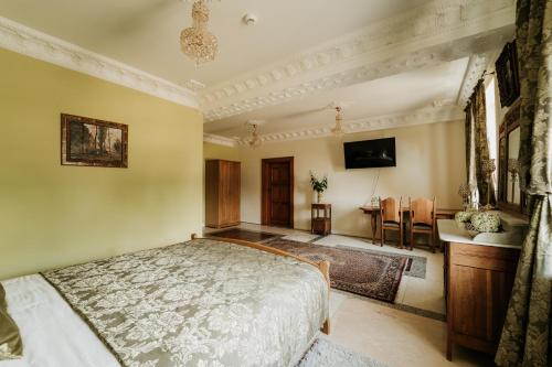 a bedroom with a bed and a table in it at Pałac Bogaczów - hotel - restauracja in Bogaczów