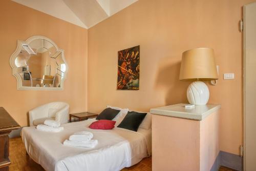 ein Schlafzimmer mit einem Bett mit einer Lampe und einem Spiegel in der Unterkunft Lemon Tree One Bedroom with Balcony in Florenz