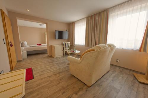 a living room with a couch and a chair in a room at Hotel Traumblick in Oberhof