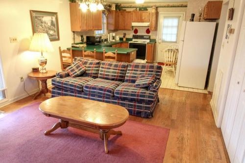 a living room with a couch and a table and a kitchen at Mountain Dew - 2 Bedrooms, 2 Baths, Sleeps 4 cabin in Gatlinburg