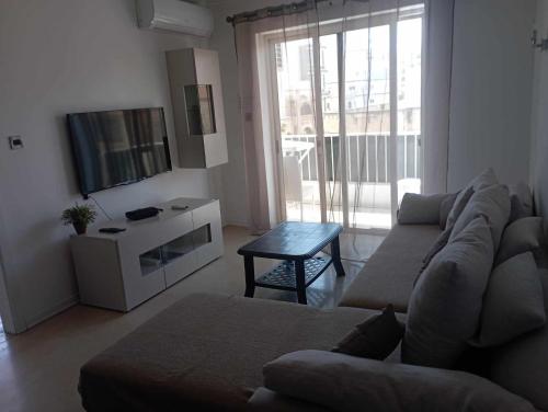un soggiorno con un divano e una TV di Cosy,central,modern Gem a San Pawl il-Baħar