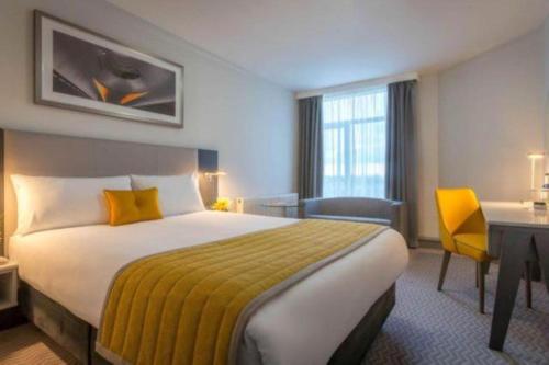 una camera d'albergo con un letto grande e una scrivania di Maldron Hotel Tallaght a Tallaght