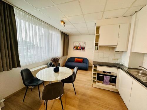 ein Wohnzimmer mit einem Tisch und Stühlen sowie eine Küche in der Unterkunft Urbanstay Suites - Grand Place 2 Bd Penthouse in Brüssel