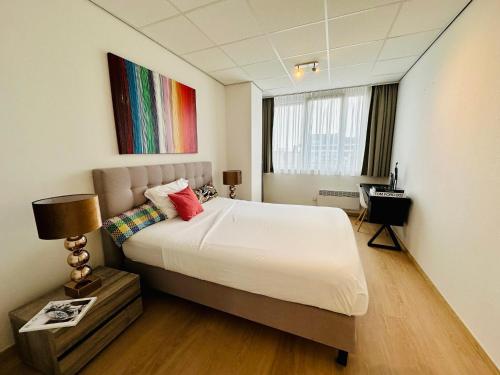 a bedroom with a bed and a colorful painting on the wall at Urbanstay Suites - Grand Place 2 Bd Penthouse in Brussels