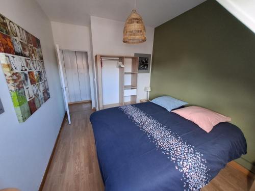 a bedroom with a bed and a green wall at A stondeta in Beauvais