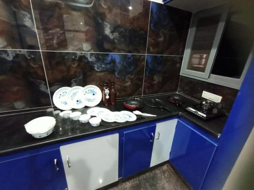een keuken met blauwe en witte gerechten op een aanrecht bij New Premium Fully Furnished 2 BHK Flats Near Station in Tirupati