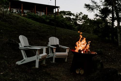 two chairs and a fire pit in a yard at Waterfall Lodge in Carool