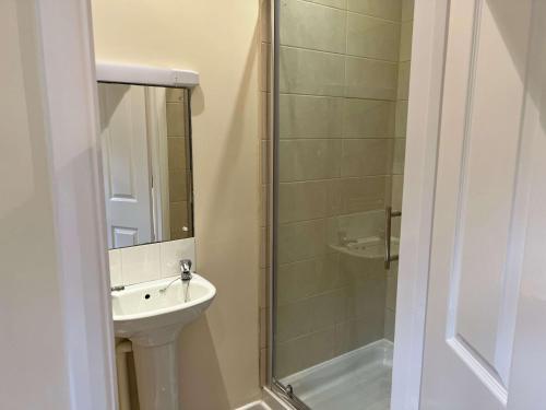 a bathroom with a sink and a shower at The Cherwell Garden Annexe in Oxford