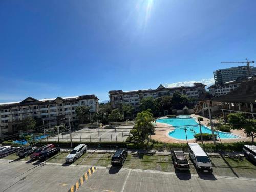 ein Parkplatz mit geparkten Autos und einem Pool in der Unterkunft One Oasis Condo 2 Bedroom Free Pool & Wifi Beside SM City Mall in Davao City