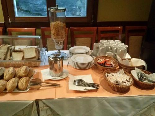 - une table avec de la nourriture, des assiettes et des ustensiles dans l'établissement Alojamiento Calzada Romana, à Belmonte de Miranda