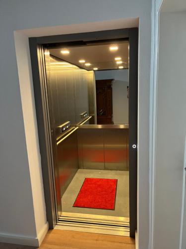 a bathroom with a red rug and a mirror at Moseltürmchen Cochem in Cochem