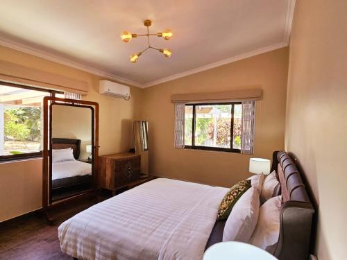 1 dormitorio con 1 cama grande y espejo en Villa Elodia by Le Duc Hotel & Villas en Mahe