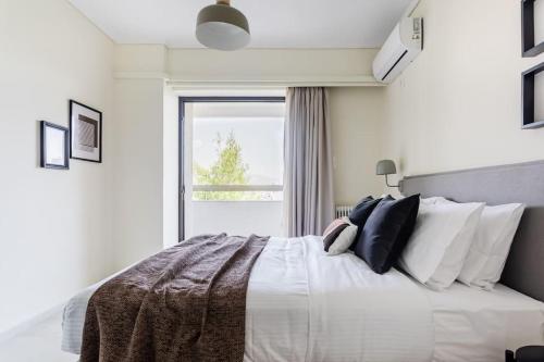 Radiant 2BR Apartment in Neo Psichiko by UPSTREET في أثينا: غرفة نوم مع سرير أبيض كبير مع نافذة