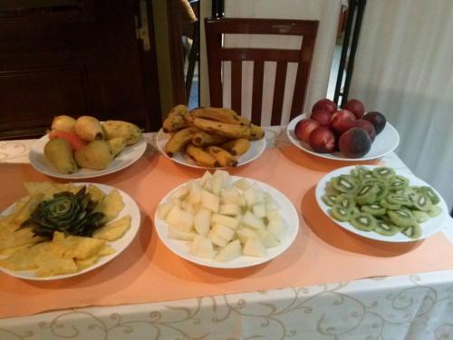 une table avec des assiettes de fruits et légumes sur elle dans l'établissement Alojamiento Calzada Romana, à Belmonte de Miranda