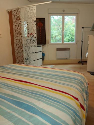 ein Schlafzimmer mit einem Bett in einem Zimmer mit einem Fenster in der Unterkunft T2 terrasse st-ferréol in Revel