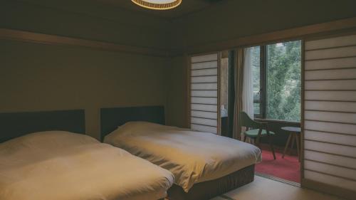 una camera con letto, finestra e scrivania di seaside hills resort izu aoitsuki a Ito