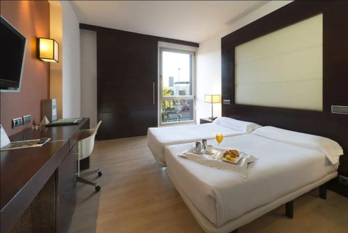 ein Hotelzimmer mit einem großen Bett und einem Tablett mit Essen darauf in der Unterkunft Eurostars i-hotel Madrid in Pozuelo de Alarcón