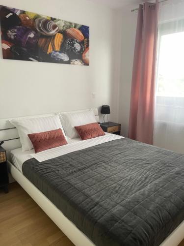 a large bed in a bedroom with a painting on the wall at Luna,central,self-check in,AC,WI-FI, washer,free parking in Zaprešić
